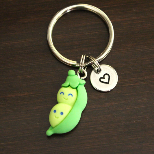 green resin two peas in a pod with faces charm keychain